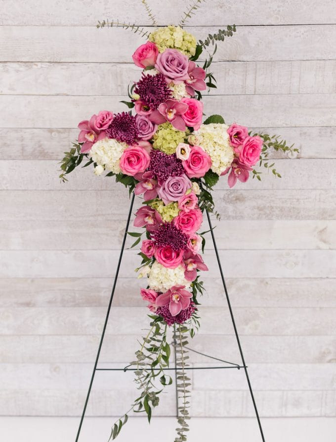 Arrangement floral rose, mauve et blanc en forme de croix