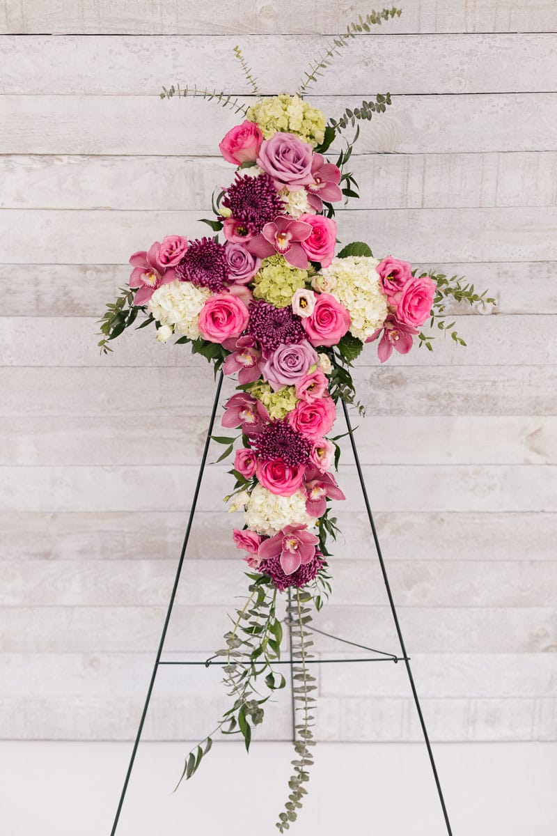 Arrangement floral rose, mauve et blanc en forme de croix