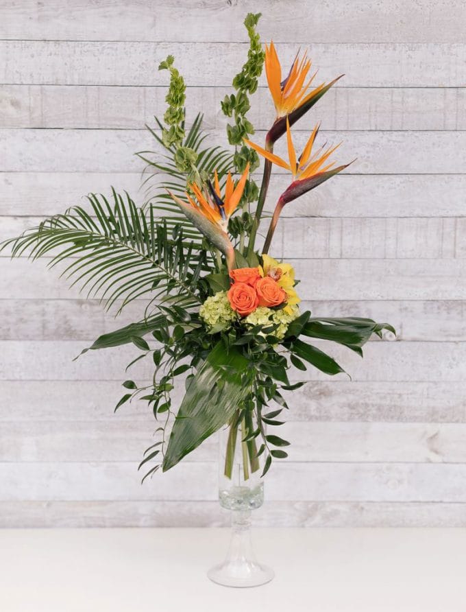 Arrangement funéraire floral dans un vase - Oiseaux de paradis et roses oranges