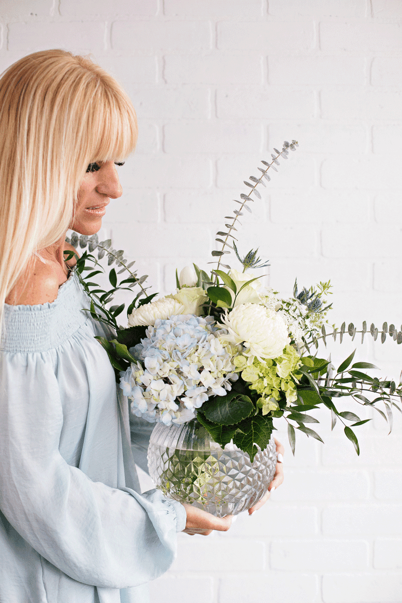 oceanna-coin-sophie-fleuriste-vase-evenement.png Bouquet rond de fleurs coupées avec vase - Hydrangées, chrysanthème, roses, éryngium, tulipes, eucalyptus, ruscus