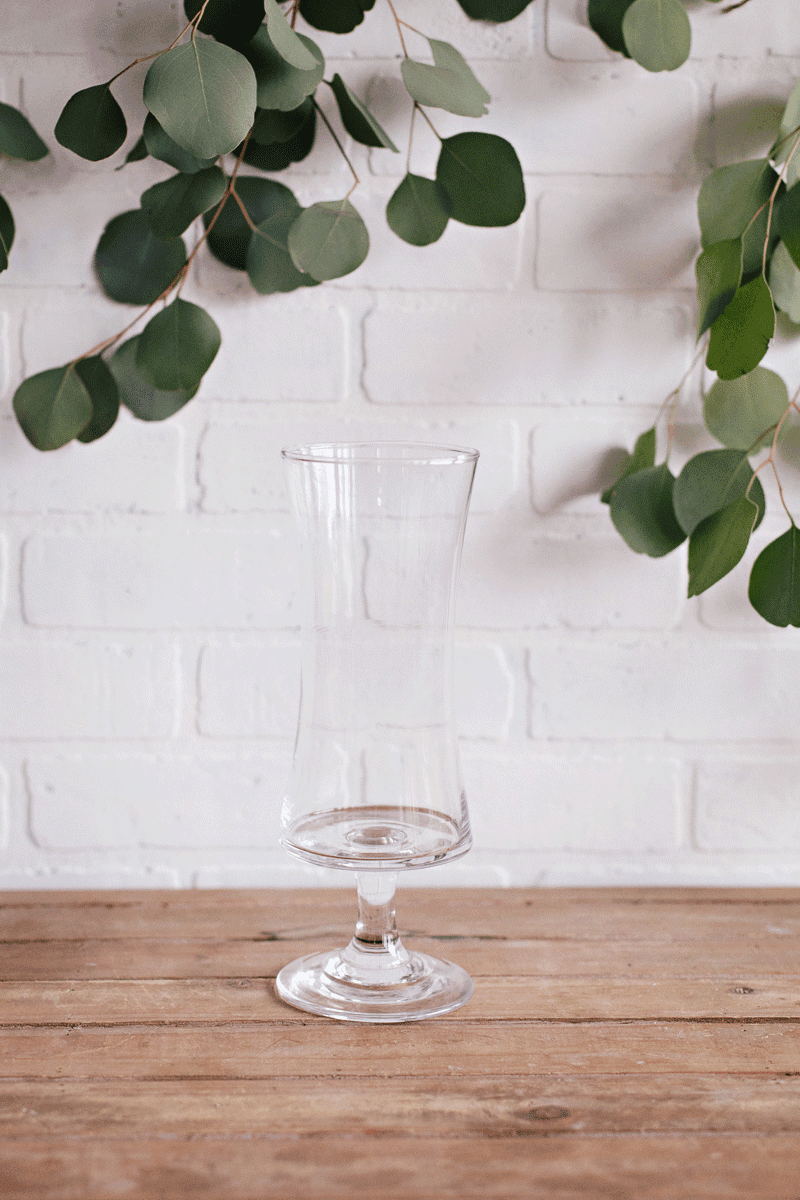 Vase long courbé sur pied en verre transparent sans motifs